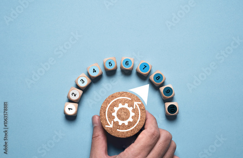 Photos Hand turning wooden knob of mechanical gear with measuring level gauge for product and service quality continuous improvement or Kaizen concept