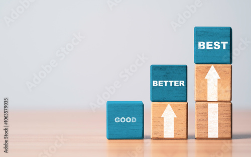 Good better and best wording on blue wooden cube block with white up arrow for product and service quality continuous improvement or Kaizen concept.