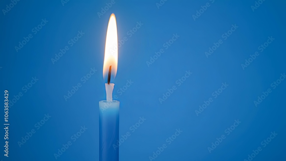 A solitary blue candle burns brightly against a vibrant blue background, illuminating the space with its flickering flame. A solitary blue candle burns brightly against a vibrant blue background, illuminating the space with its flickering flame.