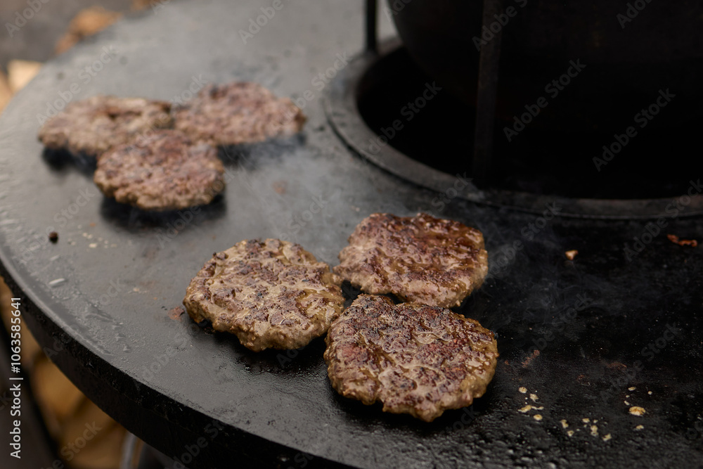 Sizzling, Mouthwatering Burgers Cooking Perfectly on a Griddle at a Summer BBQ Event Sizzling, Mouthwatering Burgers Cooking Perfectly on a Griddle at a Summer BBQ Event