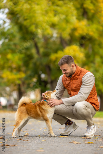 a young man with a dog in the park photo