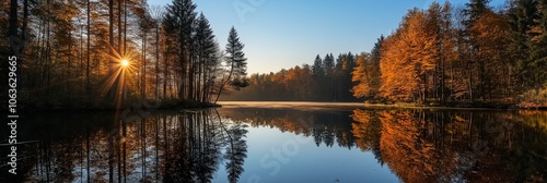 Golden sunrise illuminates a quiet lake, surrounded by vibrant autumn foliage and trees.