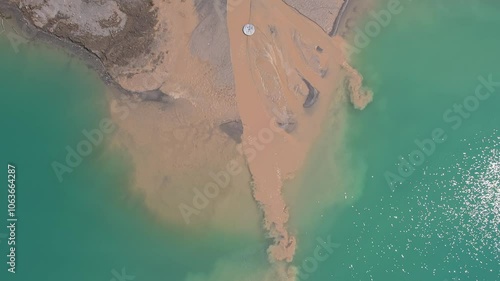 Industrial waste dropped in water and polluting the lake. Industry waste from aggregates pit waste and hazardous materials. Environmental issue around sustainability. Environment problem concept.