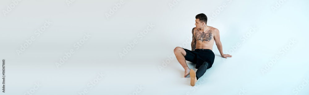 A tattooed young man relaxes in a studio, proudly displaying his prosthetic leg and artistic spirit. A tattooed young man relaxes in a studio, proudly displaying his prosthetic leg and artistic spirit.