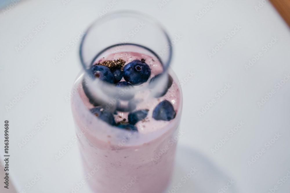 Close up of a woman making a smoothie with fruits and berries; selective focus. Healthy food concept.
