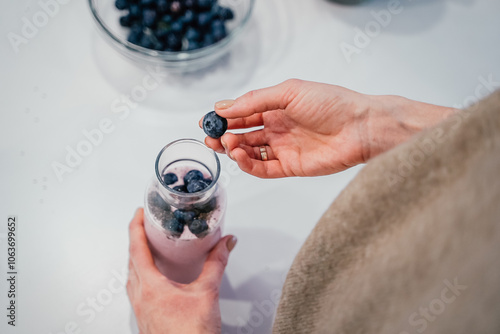 Obraz na płótnie Close up of a woman making a smoothie with fruits and berries; selective focus. Healthy food concept. w salonie