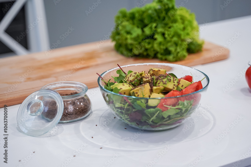 Full bowl of fresh green salad close up on a light table on a kitchen. Concept helpful and healthy food