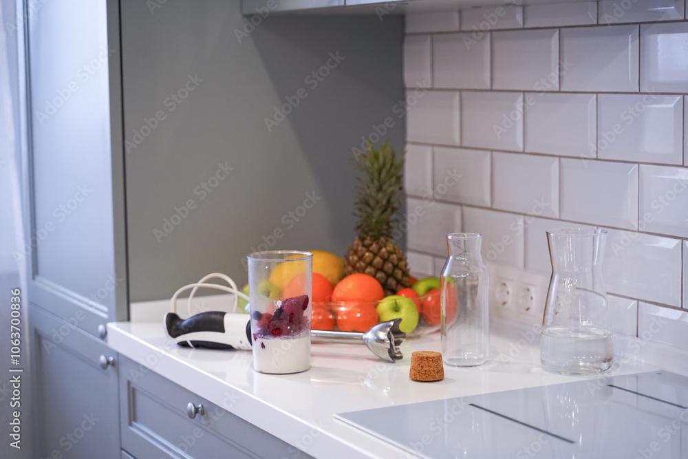 Close up of a woman making a smoothie with fruits and berries; selective focus. Healthy food concept.