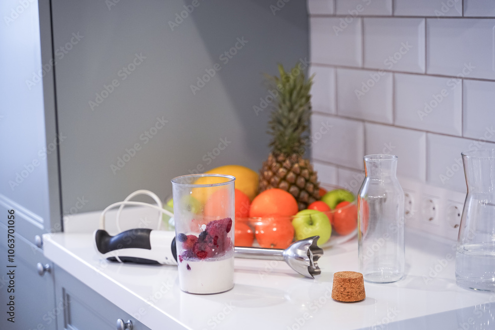 Close up of a woman making a smoothie with fruits and berries; selective focus. Healthy food concept.