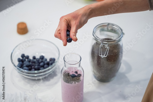Obraz na płótnie Close up of a woman making a smoothie with fruits and berries; selective focus. Healthy food concept. w salonie