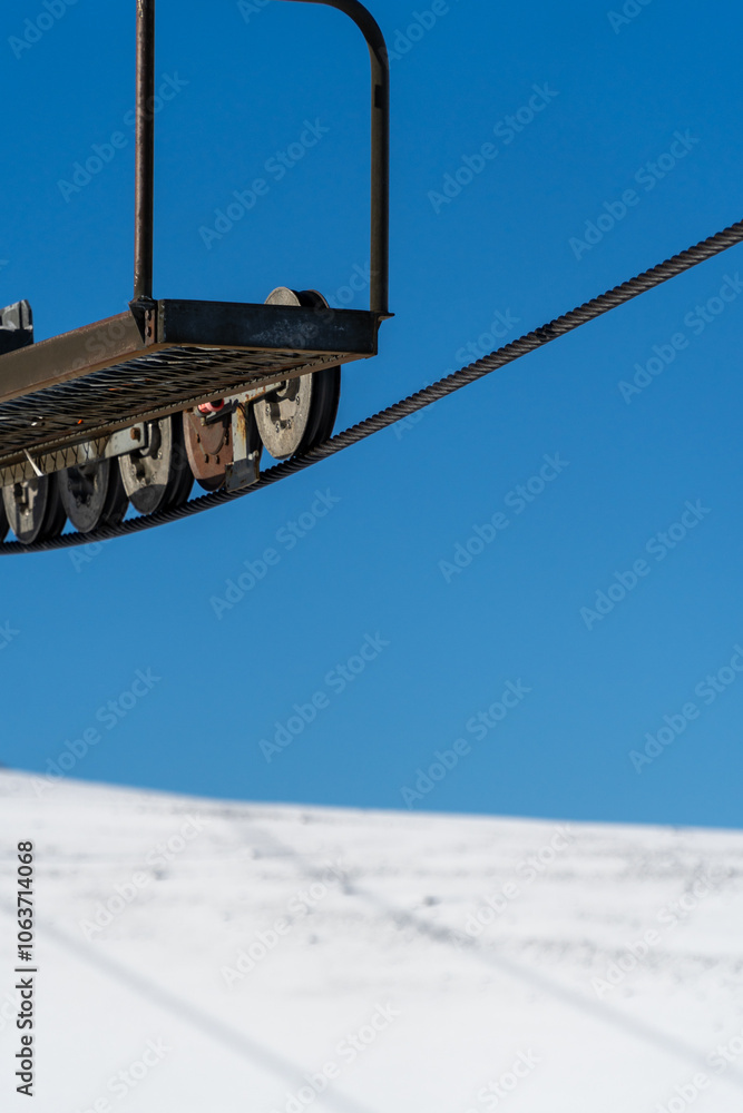 A minimalist concept of a chairlift cable against a backdrop of snow and clear blue sky, symbolizing winter sports and outdoor adventure.