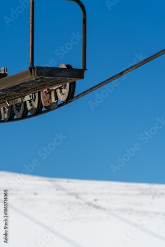 Obraz na płótnie A minimalist concept of a chairlift cable against a backdrop of snow and clear blue sky, symbolizing winter sports and outdoor adventure. w salonie