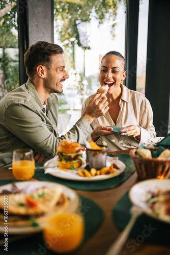 Cute couple feeding each other in a restaurant.