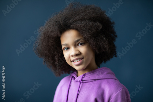 Portrait of beautiful girl with afro hairstyle close-up, dreamy look at camera,