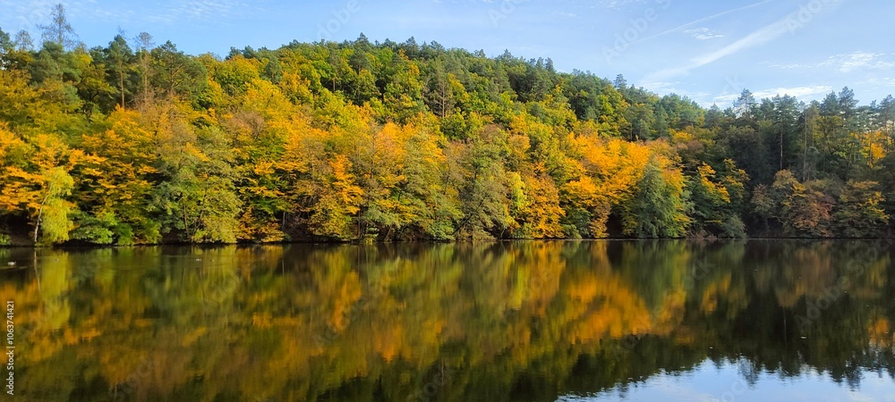 A lake with clear water, which reflects the autumn forest and sky, in the Czech Republic. Mariana Lakes A lake with clear water, which reflects the autumn forest and sky, in the Czech Republic. Mariana Lakes