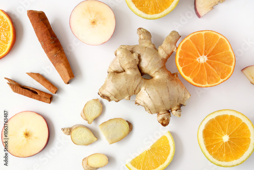 Creative layout made of ginger, orange, apple, cinnamon sticks and lemon on the white background. Flat lay. Food concept. Macro concept. 