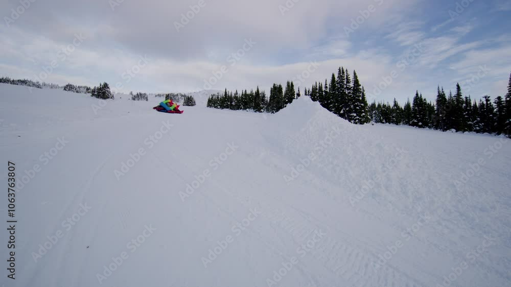 Deflating bounce house sliding down snowy mountain - slow motion Deflating bounce house sliding down snowy mountain - slow motion
