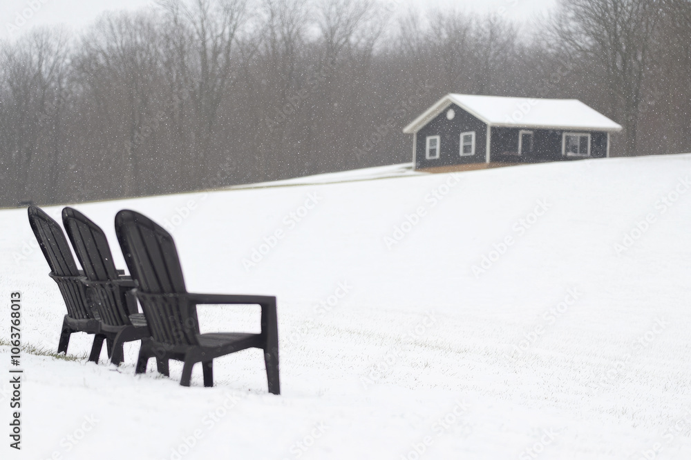 Three black chairs are sitting in the snow on a hill Three black chairs are sitting in the snow on a hill