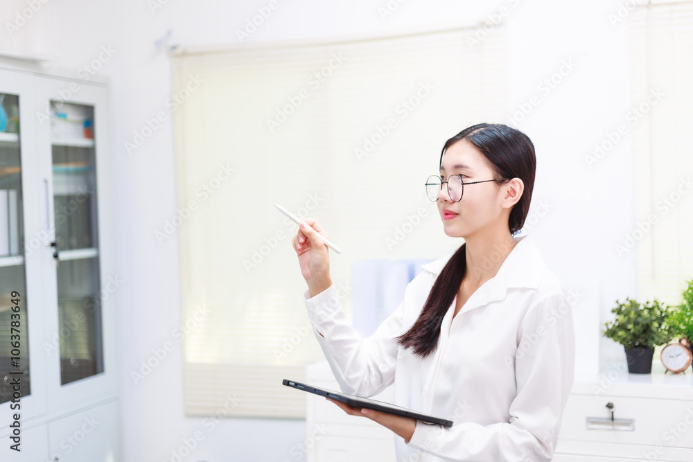 An Asian woman sits at her desk, surrounded by files , embodying dedication and professionalism in her work. An Asian woman sits at her desk, surrounded by files , embodying dedication and professionalism in her work.