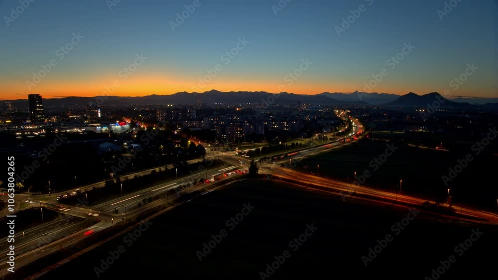 Aerial hyperlapse of a cars on a highway, heavy traffic at sunset by the city Ljubljana Aerial hyperlapse of a cars on a highway, heavy traffic at sunset by the city Ljubljana