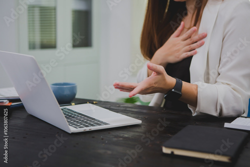 Asian businesswoman, focused , sits at ablack wooden table. Surrounded by notes , she strategizes her next move, embodying confidence and professionalism in her workspace. photo