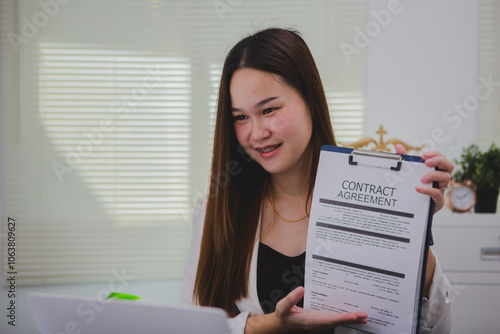 Asian businesswoman, focused , sits at ablack wooden table. Surrounded by notes , she strategizes her next move, embodying confidence and professionalism in her workspace. photo