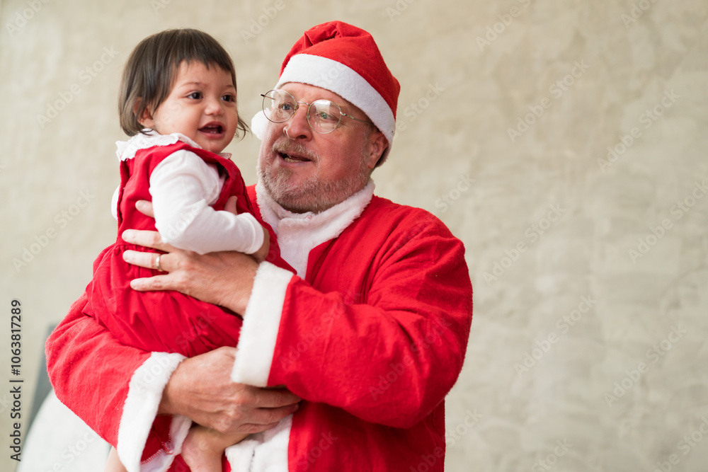 Obraz premium Santa Claus carrying baby girl