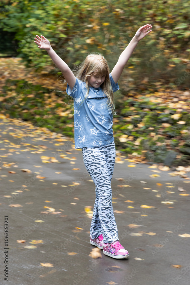 Girl (8-9 years old) on 'Heely's' wheeled shoes skating down hill