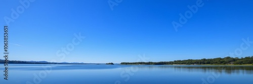 A serene landscape of a calm lake reflecting the blue sky, outdoor, environment