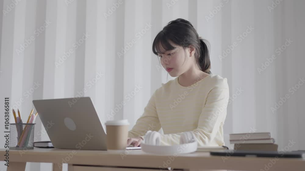 Focused Asian woman working hard studying in her room Focused Asian woman working hard studying in her room