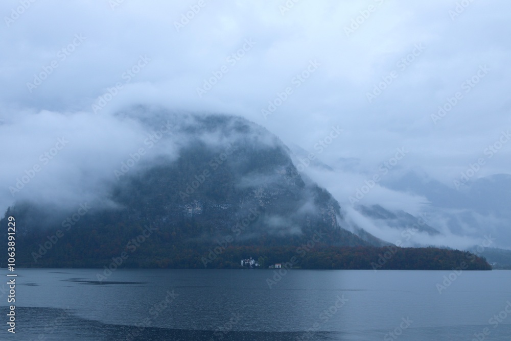 Serene Morning View of Misty Hallstatt Lake and Forested Hillside with Hidden Village, Capturing the Tranquility and Beauty of Austria’s Landscape Serene Morning View of Misty Hallstatt Lake and Forested Hillside with Hidden Village, Capturing the Tranquility and Beauty of Austria’s Landscape