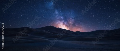 A starry night sky with a large hill in the background