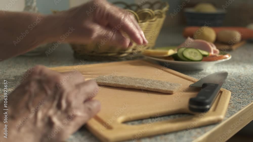 Elderly woman making sandwich with sausage and vegetables. Hands close-up. Elderly woman making sandwich with sausage and vegetables. Hands close-up.