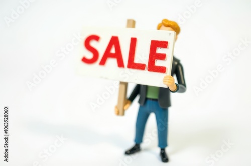 toy man holding a sign with the text (Sale)