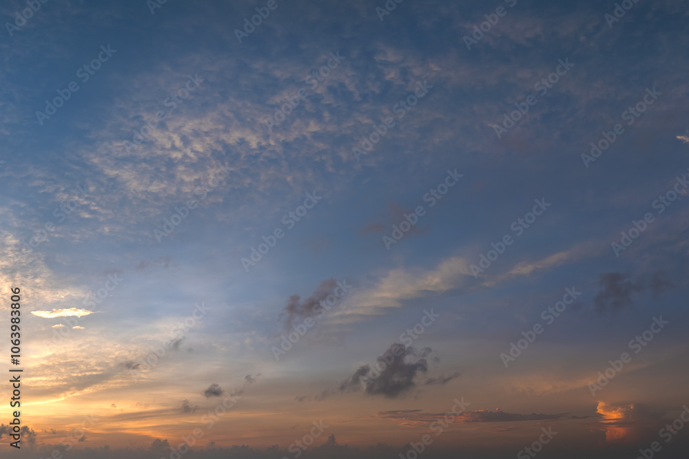 Colorful sunset sky with setting sun behind vivid orange and yellow clouds Colorful sunset sky with setting sun behind vivid orange and yellow clouds