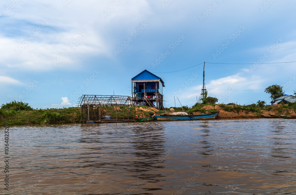 The colorful village of Kampong Phluk with houses on stilts, fishing boat and fishing nets near Siem Reap in Cambodia The colorful village of Kampong Phluk with houses on stilts, fishing boat and fishing nets near Siem Reap in Cambodia