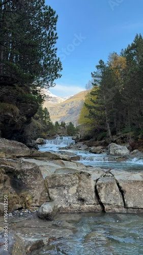 Río con pequeñas cascadas y majestuosas montañas en el Parque Nacional de Ordesa photo