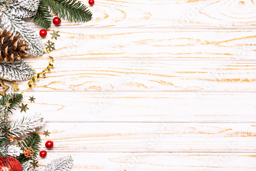 Bright Christmas and New Year border with fir tree branches, golden decorations and balls on white rustic background with copy space for your design. photo