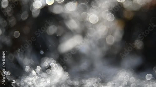 Bokeh of sunlight effects on a mountain stream in autumn sunlight, slow motion