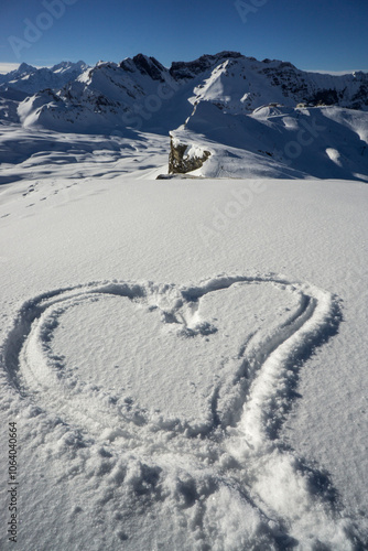 Wonderful snowshoe hike under a steel-blue sky in the Central Swiss Alps in winter on the Bonistock above Melchsee-Frutt, Switzerland. The hiking tracks remain visible in the fresh snow. photo