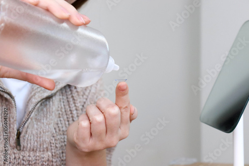 Wallpaper Mural Woman cleaning contact lenses on her hand Torontodigital.ca