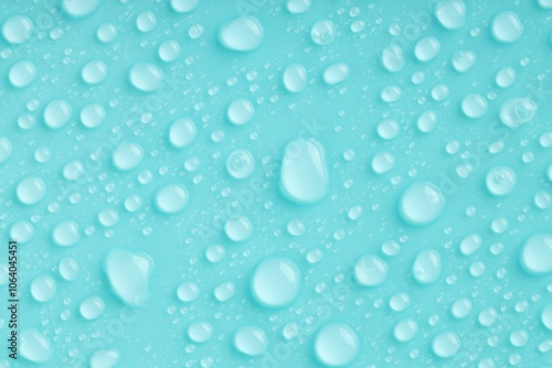 Water drops on turquoise background, top view