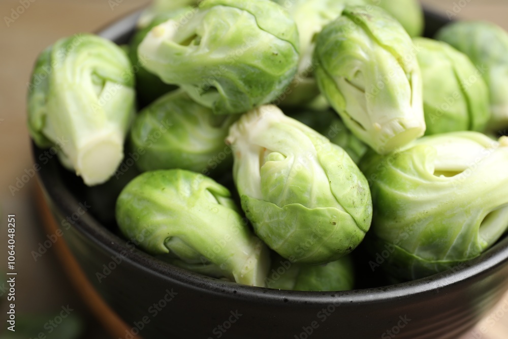 Fresh Brussels sprouts in bowl on wooden table, closeup Fresh Brussels sprouts in bowl on wooden table, closeup