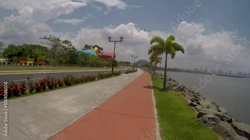 POV of a person riding a bike along the ocean in Panama City near the Biomuseo on the Amador Causeway photo