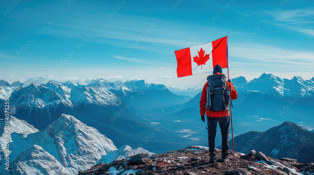 Obraz premium A hiker stands on a snow-dusted peak, waving a Canadian flag while surrounded by stunning mountain landscapes under a bright blue sky