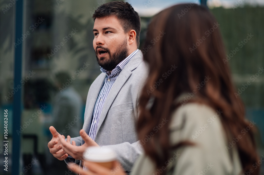 Businessman explaining something to colleague holding coffee Businessman explaining something to colleague holding coffee
