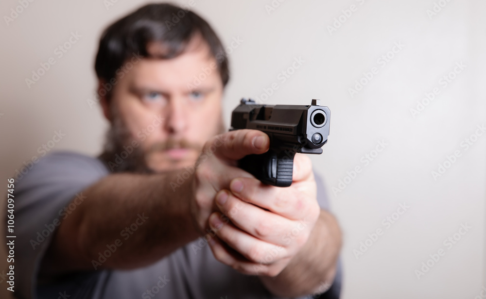 Man Aiming a Handgun with Intense Focus and Determination Man Aiming a Handgun with Intense Focus and Determination
