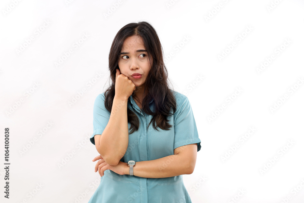 Grumpy displeased Asian female smirks face, keeps hands half crossed, holds chin, has angry expression, being deep in thoughts, dressed in casual wear, models over white wall, copy space aside Grumpy displeased Asian female smirks face, keeps hands half crossed, holds chin, has angry expression, being deep in thoughts, dressed in casual wear, models over white wall, copy space aside