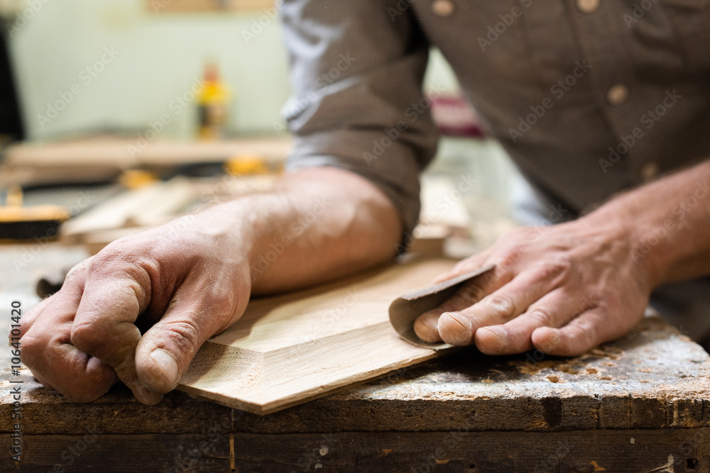 The carpenter grinds the edges of the panel with sandpaper The carpenter grinds the edges of the panel with sandpaper