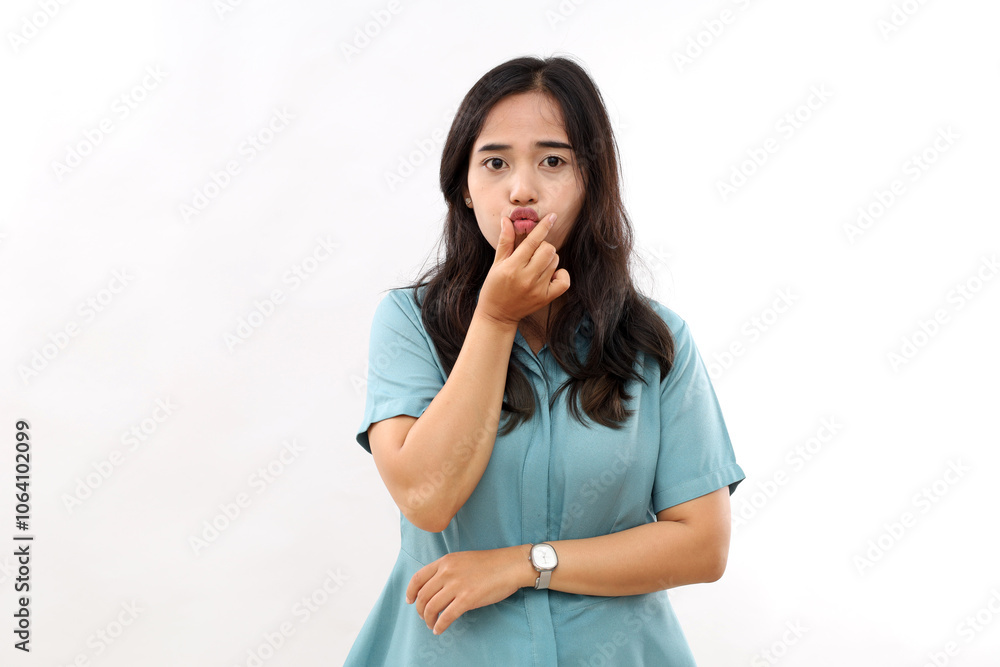 Cute young Asian woman with dark short hair keeps lips folded has surprised face didnt expect to get kiss wears shirt poses indoor. Human face expressions concept. Ethnic woman sends mwah Cute young Asian woman with dark short hair keeps lips folded has surprised face didnt expect to get kiss wears shirt poses indoor. Human face expressions concept. Ethnic woman sends mwah